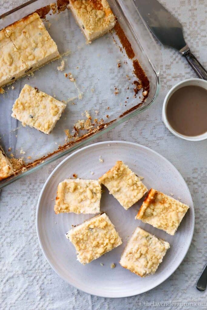 Latvian cottage cheese cake with raisins baked in a pyrex pan and served on a beige plate.