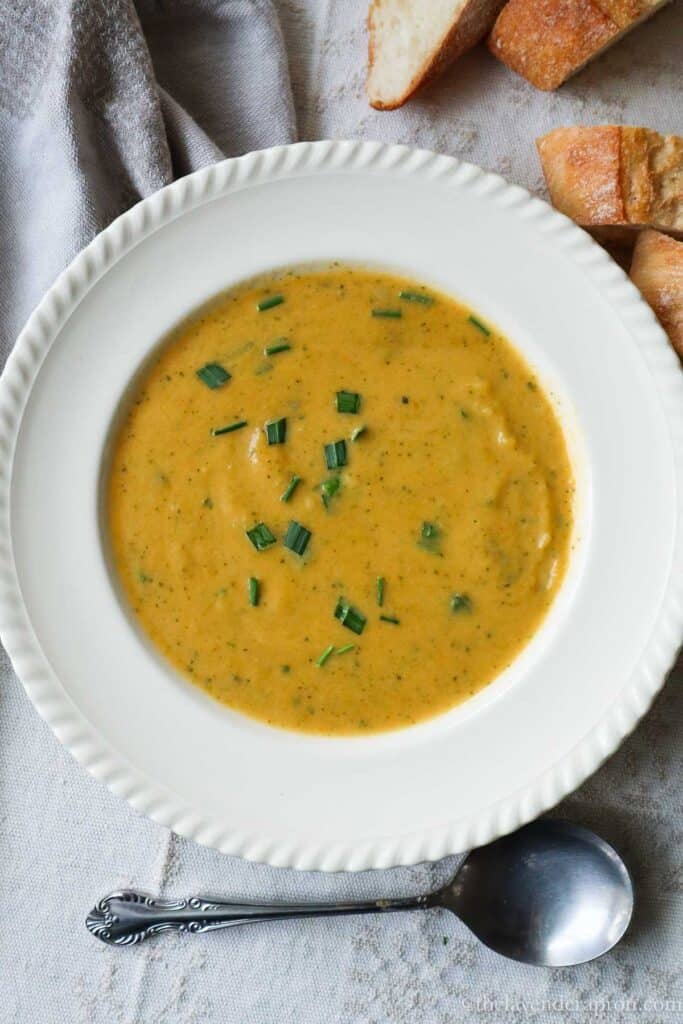 Sweet potato and broccoli soup served in a shallow beige bowl.