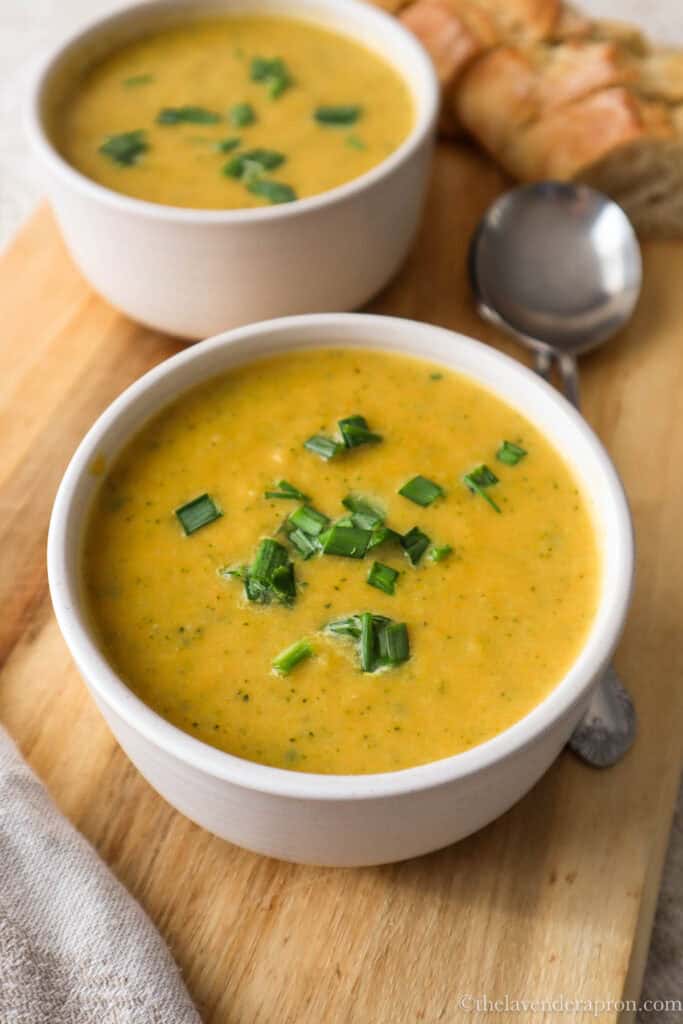 Broccoli and sweet potato soup in bowl on a wooden board.