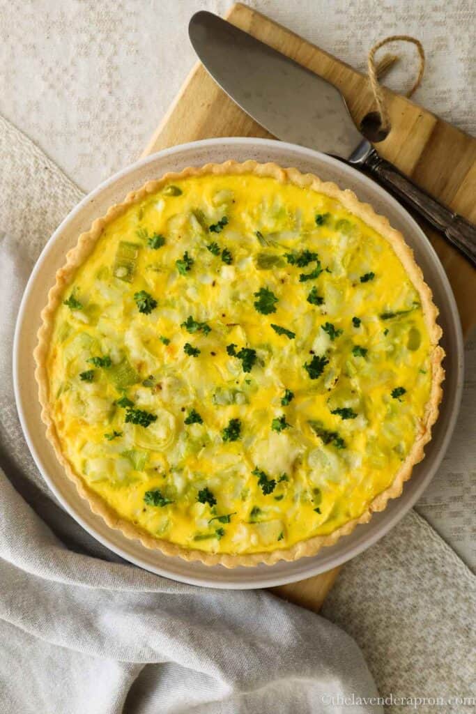 Overhead shot of leek and gruyère quiche with a serving spatula.
