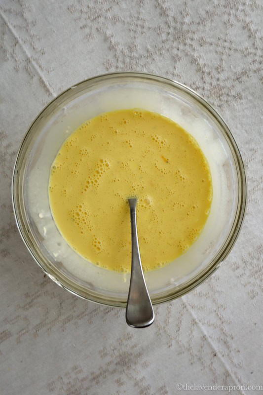 Mixing the egg custard mixture in a medium bowl.