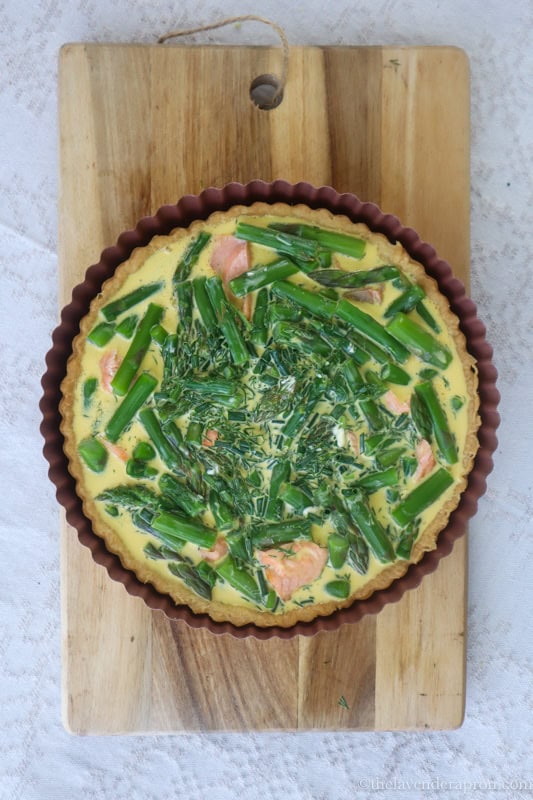 Pouring custard onto the quiche.