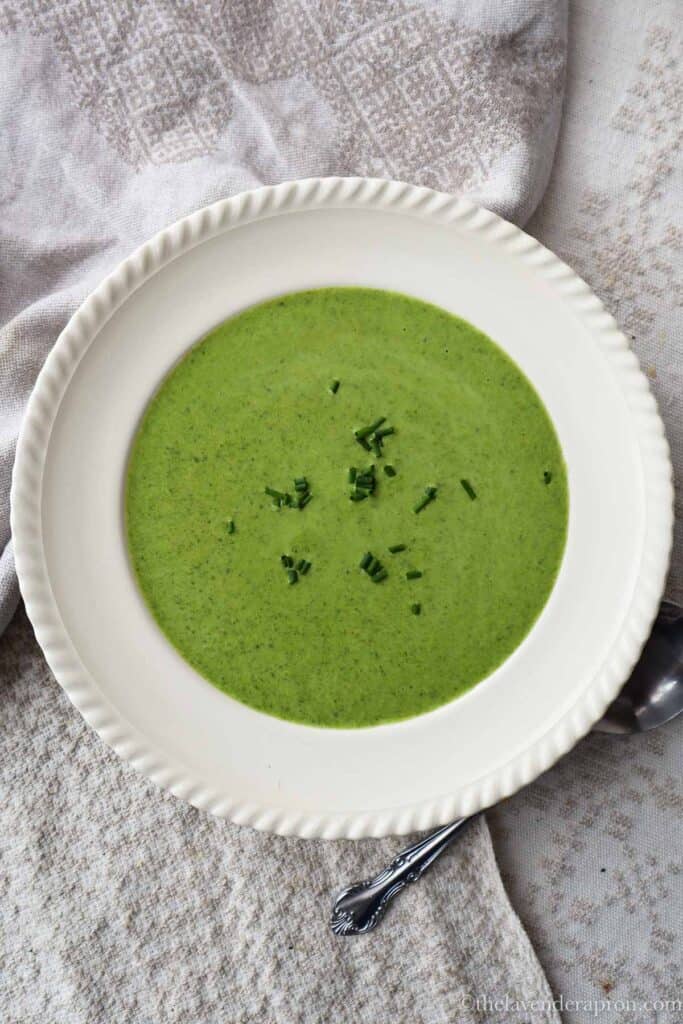 Creamy spinach leek soup in a bowl with chives as a garnish.