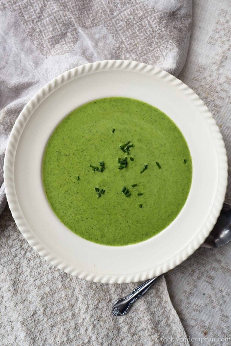 Creamy spinach leek soup in a bowl with chives as a garnish.