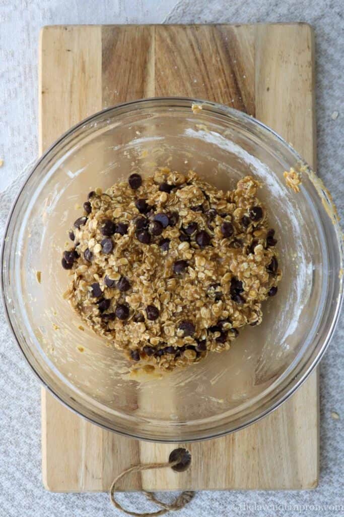 Oatmeal chocolate chip cookie dough in a glass bowl.