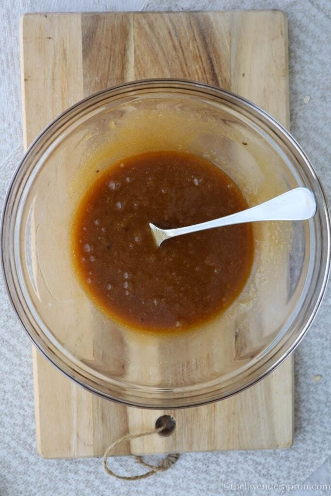 Mixing in the brown and white sugar, water and vanilla with the melted butter.