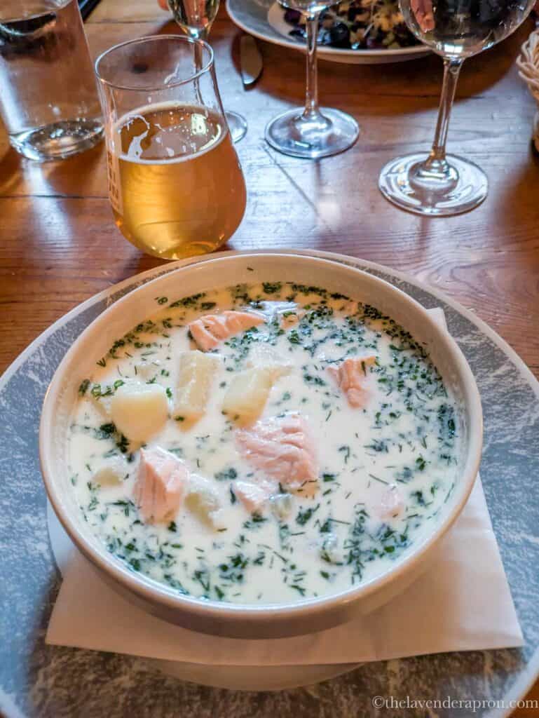 Finnish lohikeitto served in a bowl with a glass of beer in Helsinki.