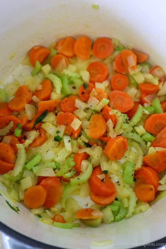 Onion, celery and sliced carrots softening in butter in a large pot.