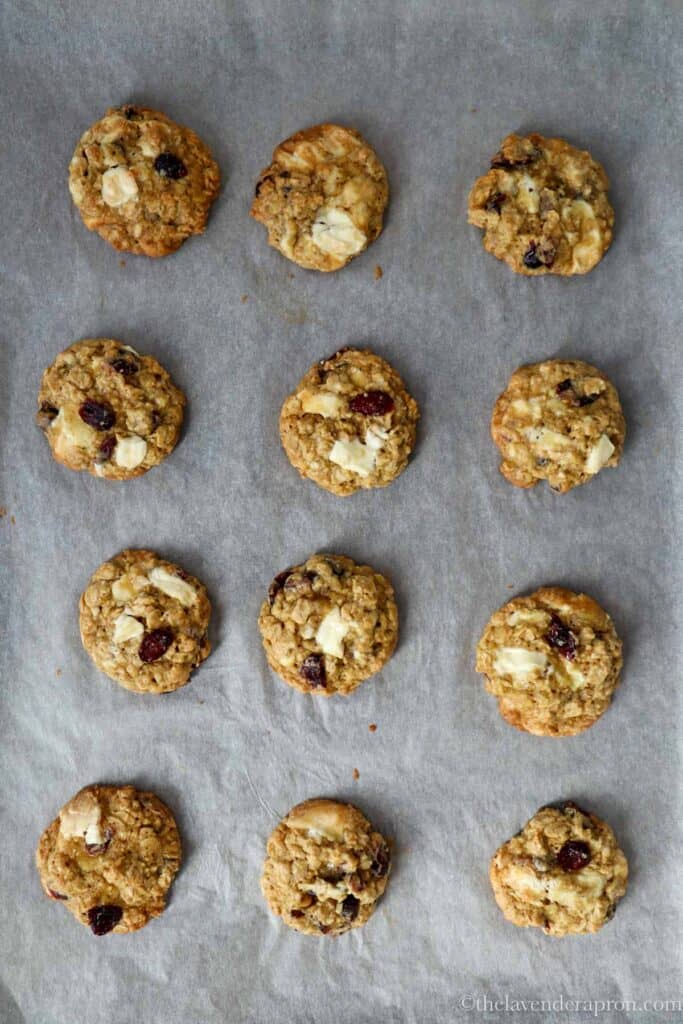 Baked oatmeal cranberry white chocolate cookies on a baking tray.
