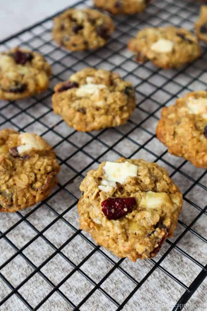 White chocolate and cranberry oatmeal cookies cooling on a wire rack.